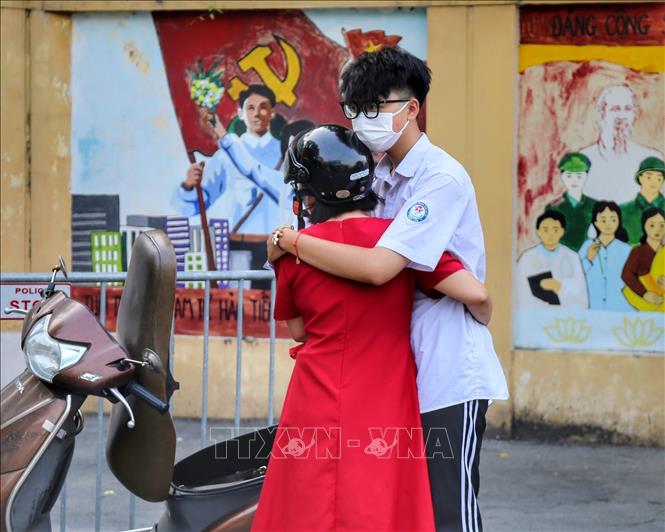 Mẹ động viên con làm bài tốt tại điểm thi trường THPT Nguyễn Gia Thiều (quận Long Biên). Ảnh: Tuấn Đức - TTXVN